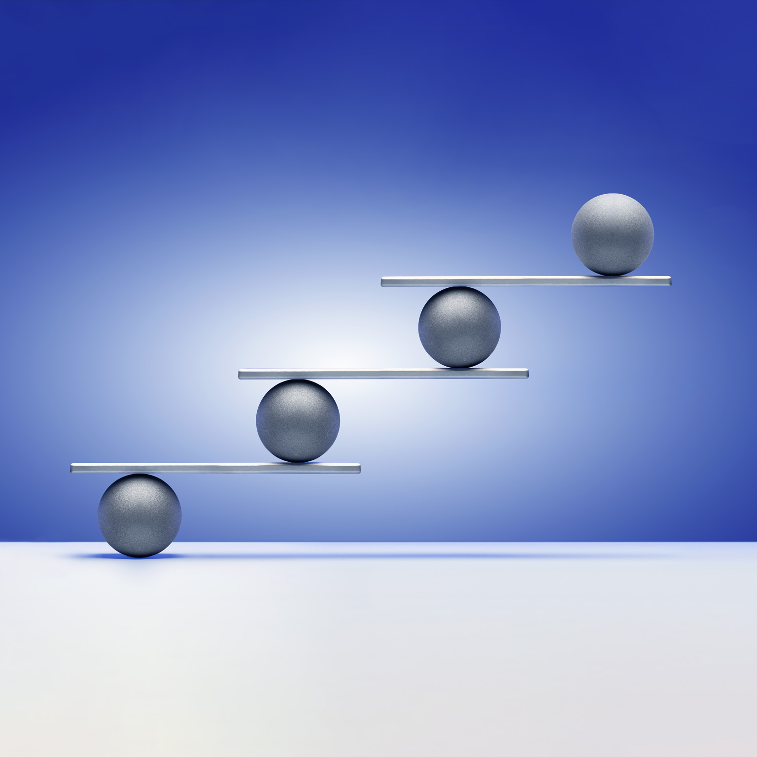 Silver colored balls on ascending white shelves, gradated blue background