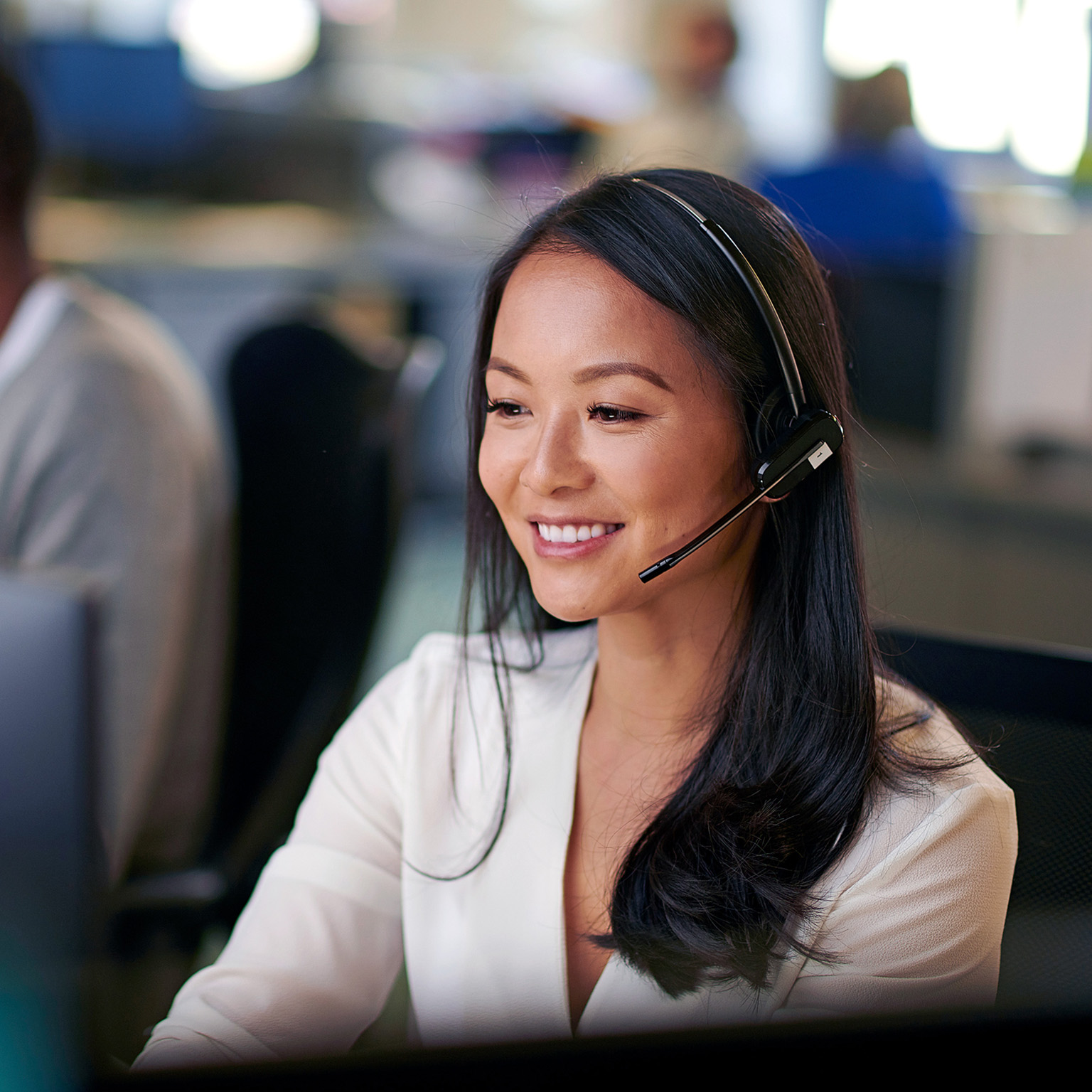 Customer support employee smiling with headset on